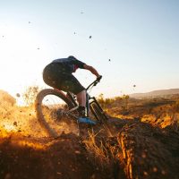 Man_on_a_mountain_bike_riding_downhill_at_sunrise_in_Alice_Springs